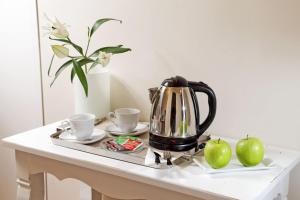 a tea kettle and two apples on a table at Residenza I Rioni Guesthouse in Rome