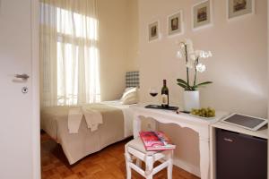 Un dormitorio con una cama y una mesa con un jarrón de flores en Residenza I Rioni Guesthouse, en Roma