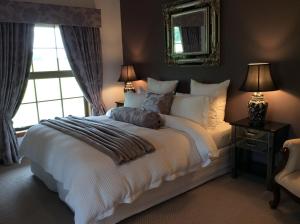 1 dormitorio con 1 cama blanca grande y ventana en Fyffe Country Lodge, en Kaikoura