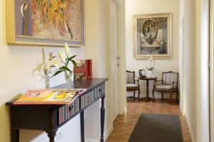 un pasillo con una mesa con libros encima en Residenza I Rioni Guesthouse, en Roma