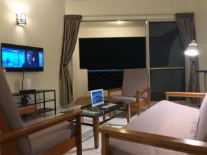 a living room with a laptop on a glass table at Comfy Beachfront View at Seri Bulan Condominium Teluk Kemang Beach in Port Dickson