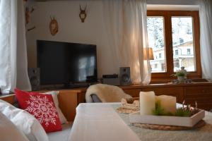 a living room with a television and a bed with a table at Ferienhaus am Gebraweg in Fieberbrunn in Tirol - Saalbach, Leogang, Hochfilzen, Kitzbühel in Fieberbrunn