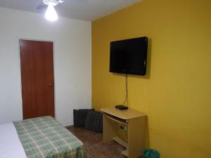 ベロオリゾンテにあるHostel Geraisのベッドと壁にテレビが掛かった寝室