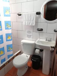 y baño con aseo y lavamanos. en Hostal D´Mathias, en Baños
