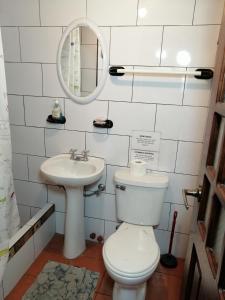 La salle de bains est pourvue de toilettes et d'un lavabo. dans l'établissement Hostal D´Mathias, à Baños