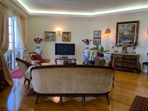 a living room with a couch and a tv at Vila Tagus Garajau in Caniço