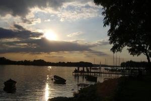 ツァプリネクにあるDom Wczasowy Pięciu Pomostów I DOMKI LETNISKOWEの水上のボートを使った湖上の夕日