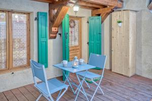 un tavolo e sedie su una veranda con porte verdi di Studio "Cosy" hyper centre a Saint-Gervais-les-Bains