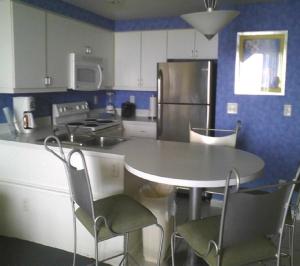 La cuisine est équipée d'une table, de chaises et d'un réfrigérateur. dans l'établissement Ocean Walk Resort 1709i, à Daytona Beach
