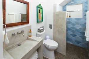 a bathroom with a sink and a toilet and a mirror at Villa Dorado - Duplex in Sayulita