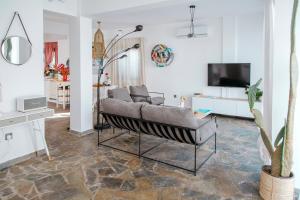ein Wohnzimmer mit einem Sofa und einem TV in der Unterkunft Island Home Seaside Villa in Paralimni