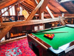 a pool table in the middle of a room at Chalet 1703 - Open Living Hotel & Spa in Le Petit-Bornand-lès-Glières