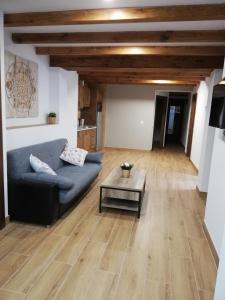 ein Wohnzimmer mit einem Sofa und einem Tisch in der Unterkunft Puente Viejo de Buitrago CASA ROBLE in Buitrago del Lozoya