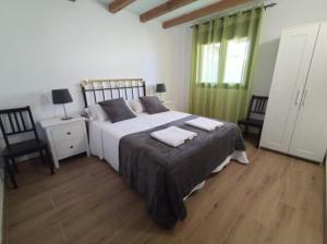 1 dormitorio con 1 cama con 2 toallas en Puente Viejo de Buitrago CASA ROBLE en Buitrago del Lozoya