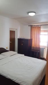 ein Schlafzimmer mit einem großen weißen Bett und einem Fenster in der Unterkunft Vila MDM in Straja