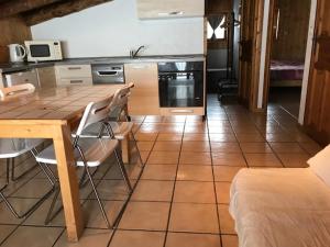 a kitchen with a wooden table and chairs in a room at Appartement Montgenevre pied de pistes in Montgenèvre