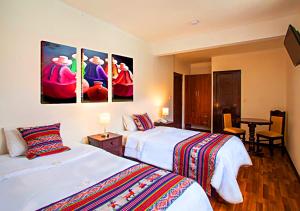 a hotel room with two beds and a television at Hotel Santa Maria in Cusco