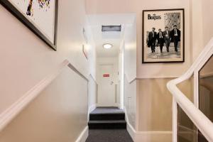 un couloir avec un escalier avec une photo sur le mur dans l'établissement Enrico Hotel, à Londres