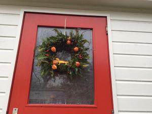 a red door with a christmas wreath on it at Repelsteeltje op Terschelling in Formerum