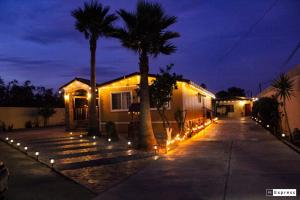 a house with palm trees and lights in a driveway at Cabaña R y A Valle de Guadalupe in Valle de Guadalupe