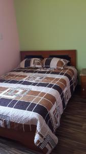 Una cama con una manta azul y marrón. en Los Geranios, en Yanque
