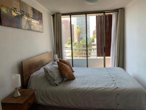 1 dormitorio con cama y ventana grande en Depto. Excelente vista al Cerro San Cristobal !!, en Santiago