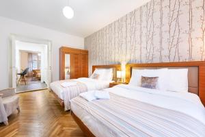 two beds in a hotel room with white walls at Prague Roof Apartments in Prague