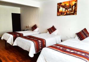 a hotel room with two beds and two lamps at Hotel Santa Maria in Cusco