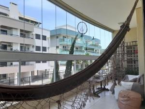 a hammock in a room with a building at Apartamento Terra Nova Mariscal in Bombinhas