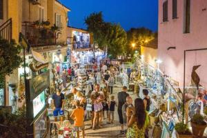 una multitud de personas caminando por un mercado de noche en casa Antony en San Teodoro