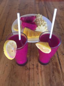 two glasses of pink juice and a plate of food at my house guest house in batumadeg