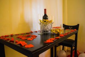 una mesa con una botella de vino y servilletas naranjas en Hotel Plaza Palmero, en San Pedro Sula