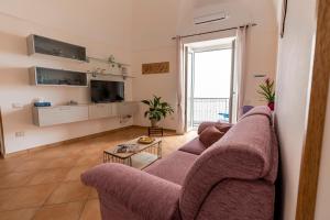 sala de estar con sofá púrpura y TV en Casa Vacanza da Giggino, en Ravello