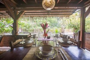 uma sala de jantar com uma mesa de madeira com pratos e tigelas em Casa Matix em Puerto Viejo