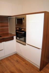 uma cozinha com um frigorífico e um micro-ondas em Riverside Apartman with Free Parking em Győr