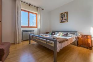a bedroom with a bed and a large window at Apartment Roni in Crikvenica