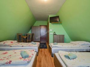 a green room with three beds and a tv at Dom Wczasowy " U Józefa " in Zakopane