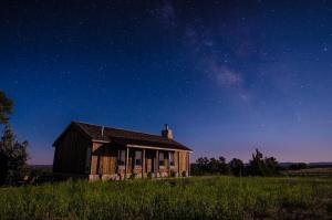 an old house in a field under a night sky at Zion Mountain Ranch in Mount Carmel Junction