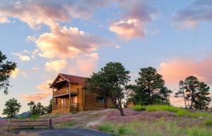 a wooden house sitting on top of a hill at Zion Mountain Ranch in Mount Carmel Junction