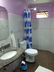 a bathroom with a sink and a toilet and a mirror at Pousada Das Cores in Cumuruxatiba +40 photos