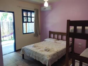 a bedroom with a bed with two towels on it at Pousada Das Cores in Cumuruxatiba