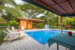 a patio with a table and chairs and a pool at Casa Margarita in Puerto Viejo