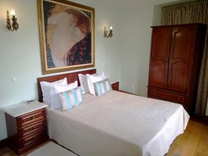 Un dormitorio con una cama blanca y un cuadro en la pared. en Safira, en Lisboa 30 fotos más