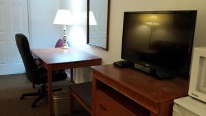 a desk with a television and a lamp on top of it at Redwood Motor Inn in Brandon