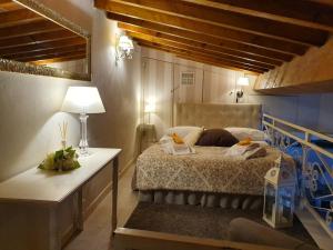 um quarto com uma cama e uma mesa com um candeeiro em Apartment Ponte Vecchio em Florença
