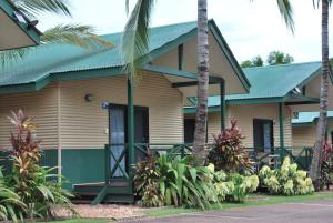 a house with a green door and palm trees at Hidden Valley Holiday Park Darwin in Darwin