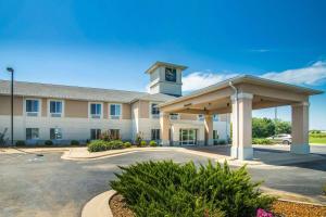 a large building with a clock tower in a parking lot at Quality Inn in Parsons