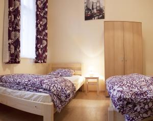 a bedroom with two beds and a window with curtains at Garden House in Budapest