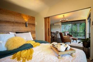 a bedroom with a large bed and a dining room at L'amour Nest in Napier