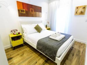 a bedroom with a white bed and a yellow table at Apartamento com 2 Quartos em Alto de Pinheiros in Sao Paulo